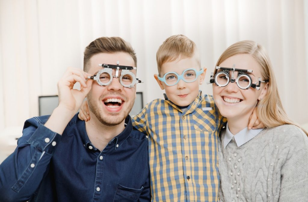 Cheerful family at the eyes doctor ready to have their eye exams.